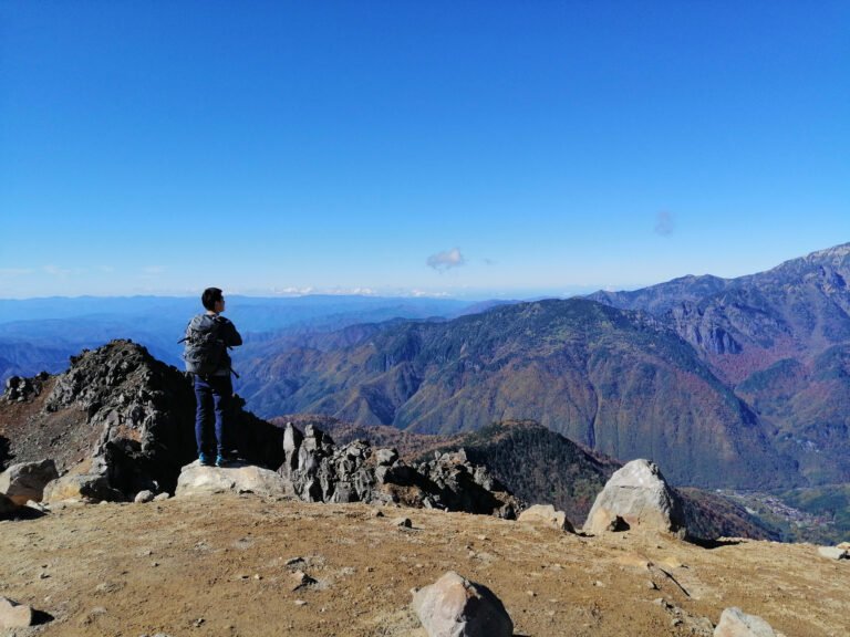 A man standing on the summit of Yakedake.